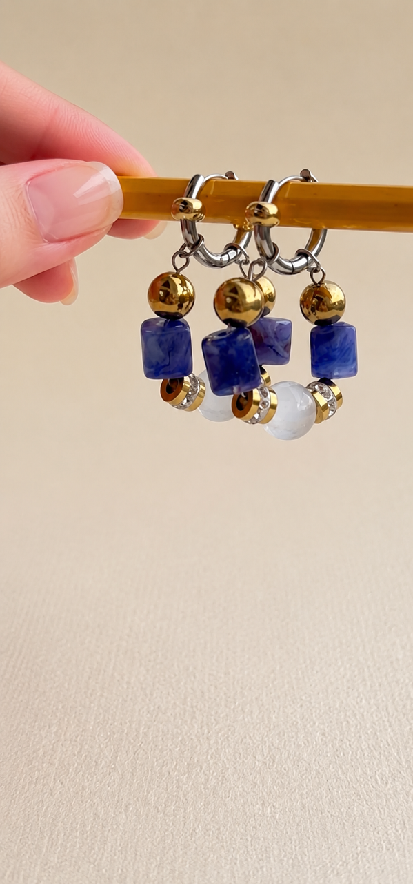 Boucles d'oreilles dorées sur sable