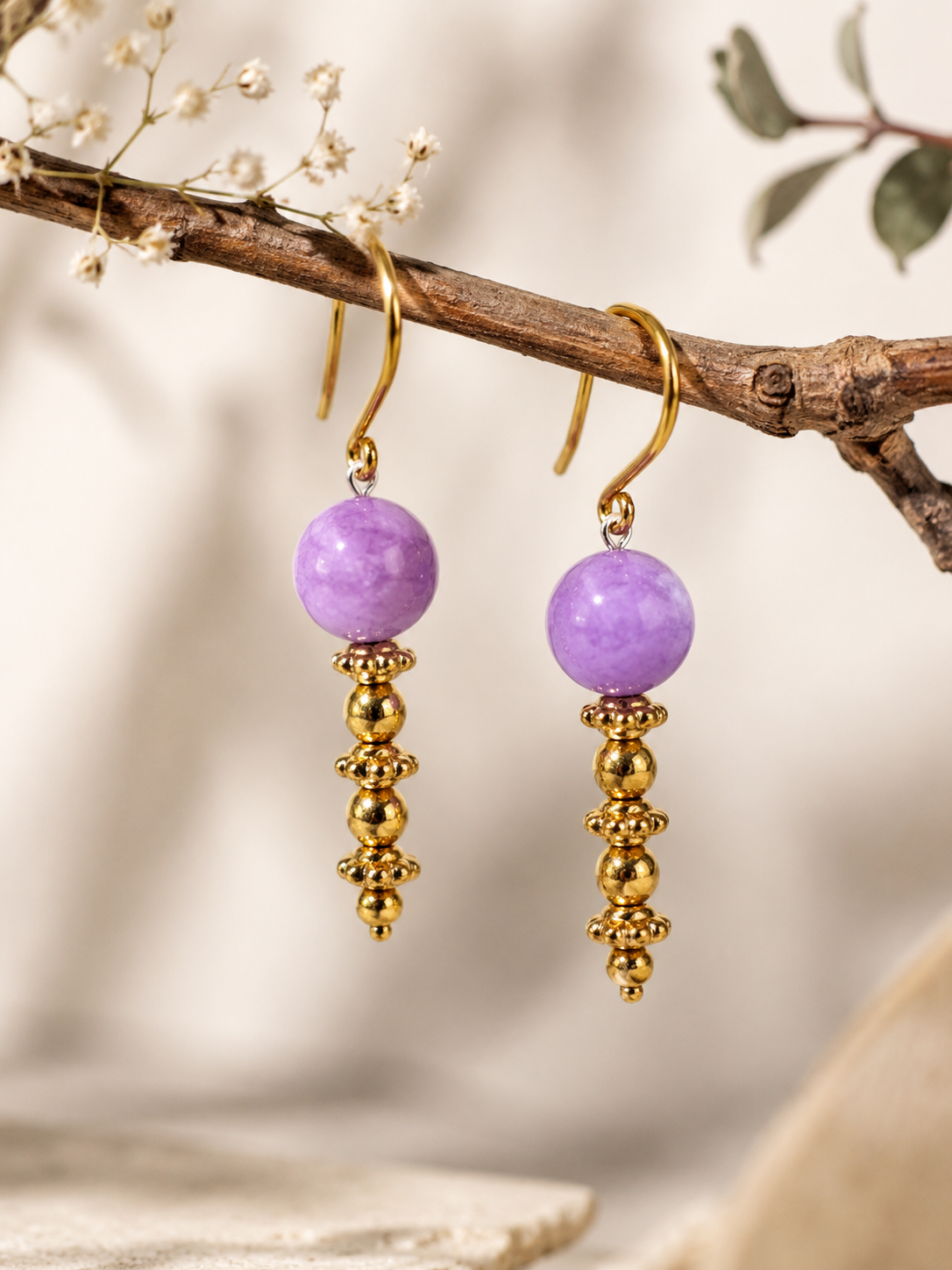 Boucles d'oreilles dorées sur sable